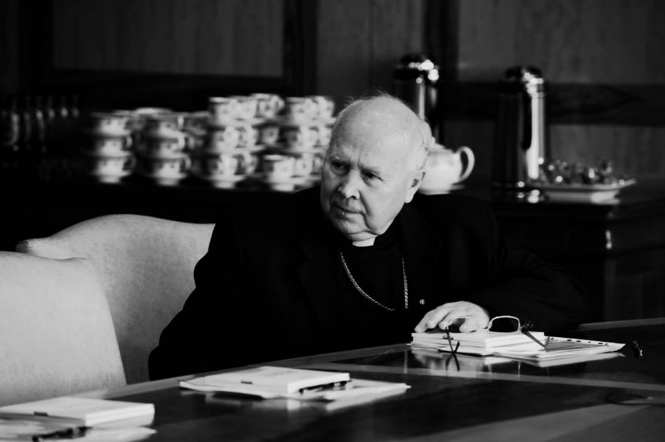 postać arcybiskupa Tadeusza Gocłowskiego, siedzącego przy stole podczas rady nadzorczej fundacji